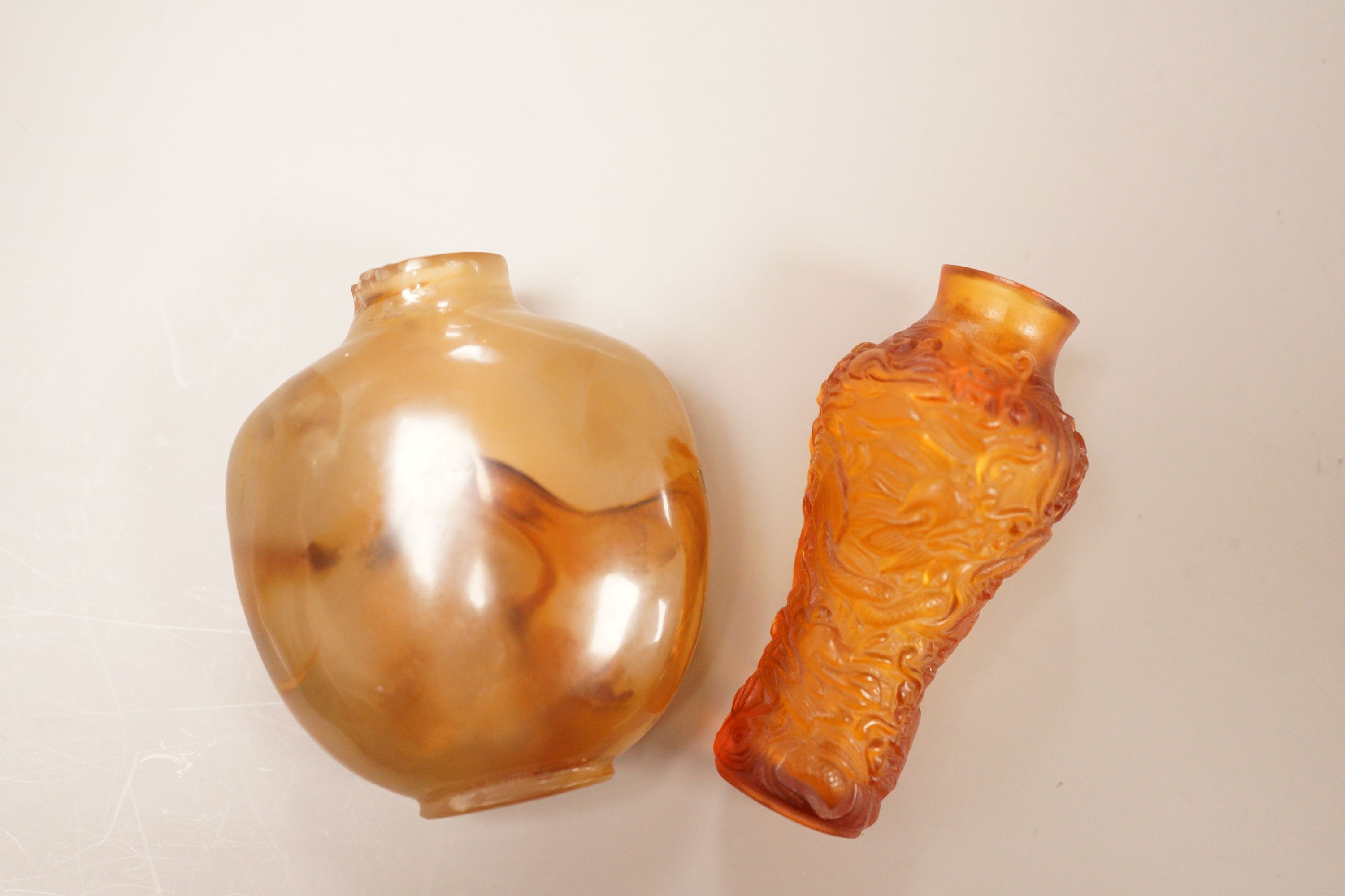 A Chinese agate snuff bottle and an amber glass snuff bottle